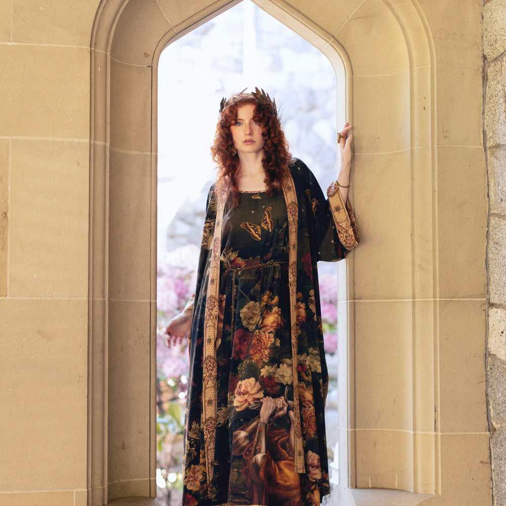
                  
                    Model wearing a maxi-length bamboo-viscose slip dress featuring florals from centuries-old paintings and Rosetti’s iconic portrait of Joan of Arc - Market of Stars
                  
                
