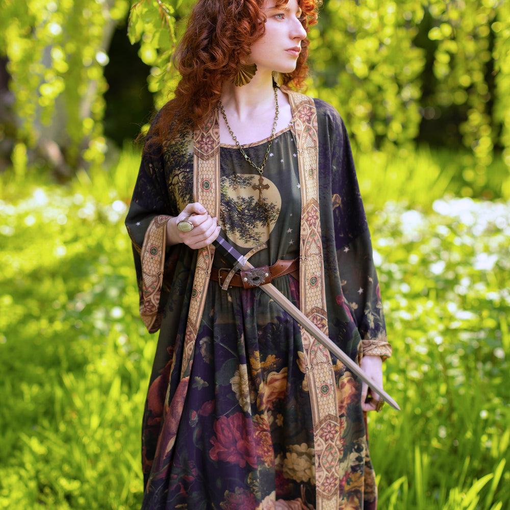 
                  
                    Model wearing a maxi-length bamboo-viscose slip dress featuring florals from centuries-old paintings and Rosetti’s iconic portrait of Joan of Arc - Market of Stars
                  
                
