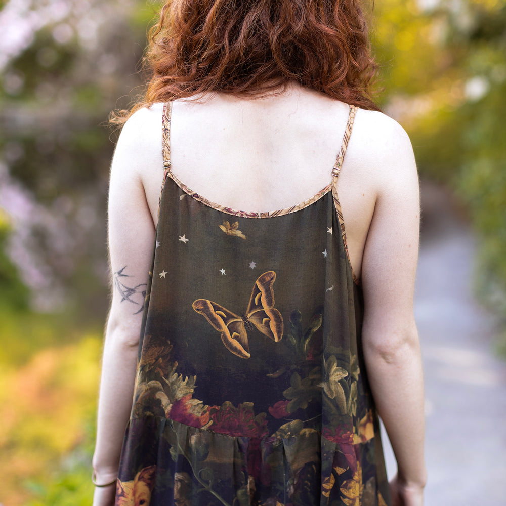 
                  
                    Model wearing a maxi-length bamboo-viscose slip dress featuring florals from centuries-old paintings and Rosetti’s iconic portrait of Joan of Arc - Market of Stars
                  
                