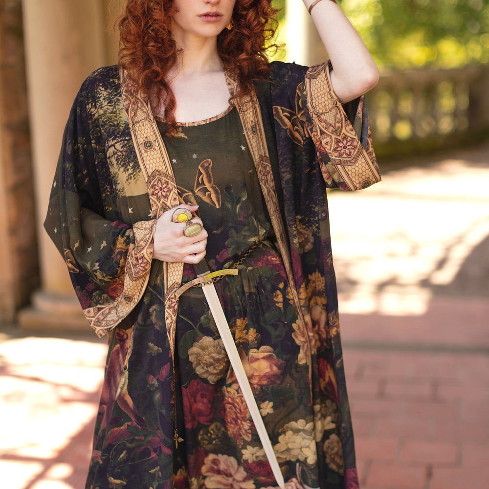 
                  
                    Model wearing a maxi-length bamboo-viscose slip dress featuring florals from centuries-old paintings and Rosetti’s iconic portrait of Joan of Arc - Market of Stars
                  
                