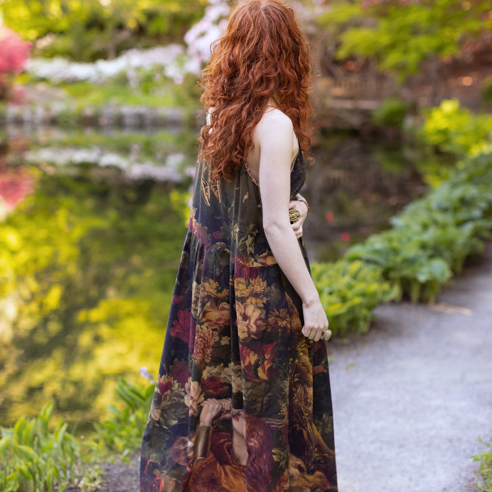 
                  
                    Model wearing a maxi-length bamboo-viscose slip dress featuring florals from centuries-old paintings and Rosetti’s iconic portrait of Joan of Arc - Market of Stars
                  
                