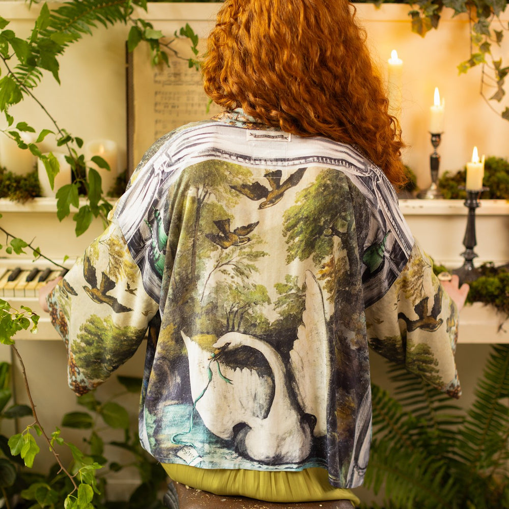 Model wearing the cropped Theatre of Dreams kimono featuring painted swan, antique script, and whimsical theatre imagery from artist Jennifer Lanne