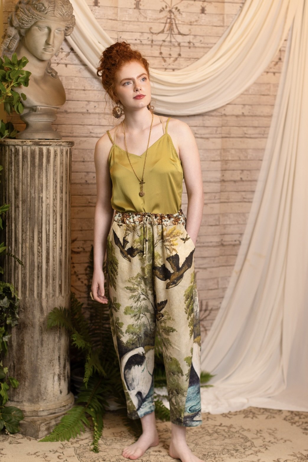 Model wearing Theatre of Dreams Artist Pants with lantern-hem silhouette featuring antique landscape, swan, and painted birds by artist Jennifer Lanne