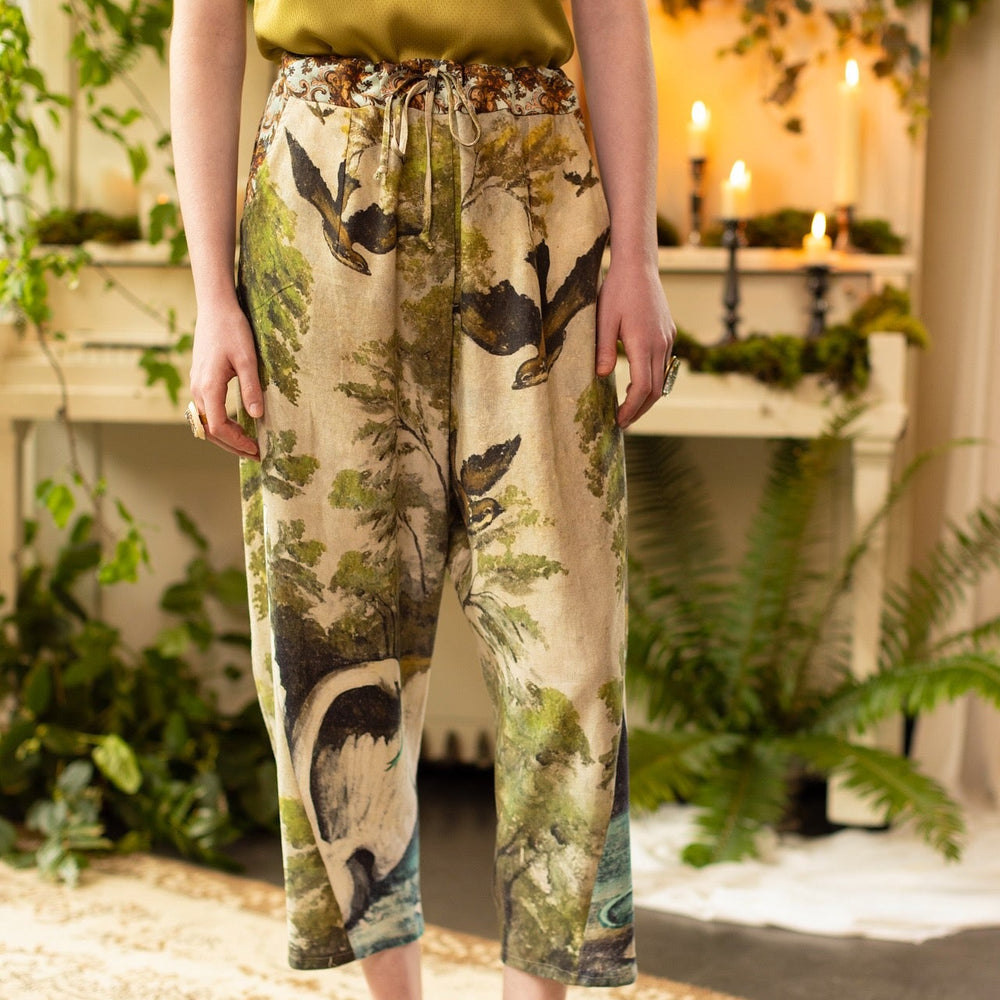 Model wearing Theatre of Dreams Artist Pants with lantern-hem silhouette featuring antique landscape, swan, and painted birds by artist Jennifer Lanne