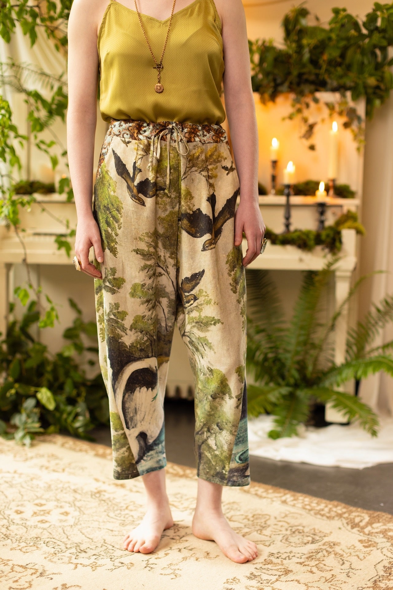 Model wearing Theatre of Dreams Artist Pants with lantern-hem silhouette featuring antique landscape, swan, and painted birds by artist Jennifer Lanne