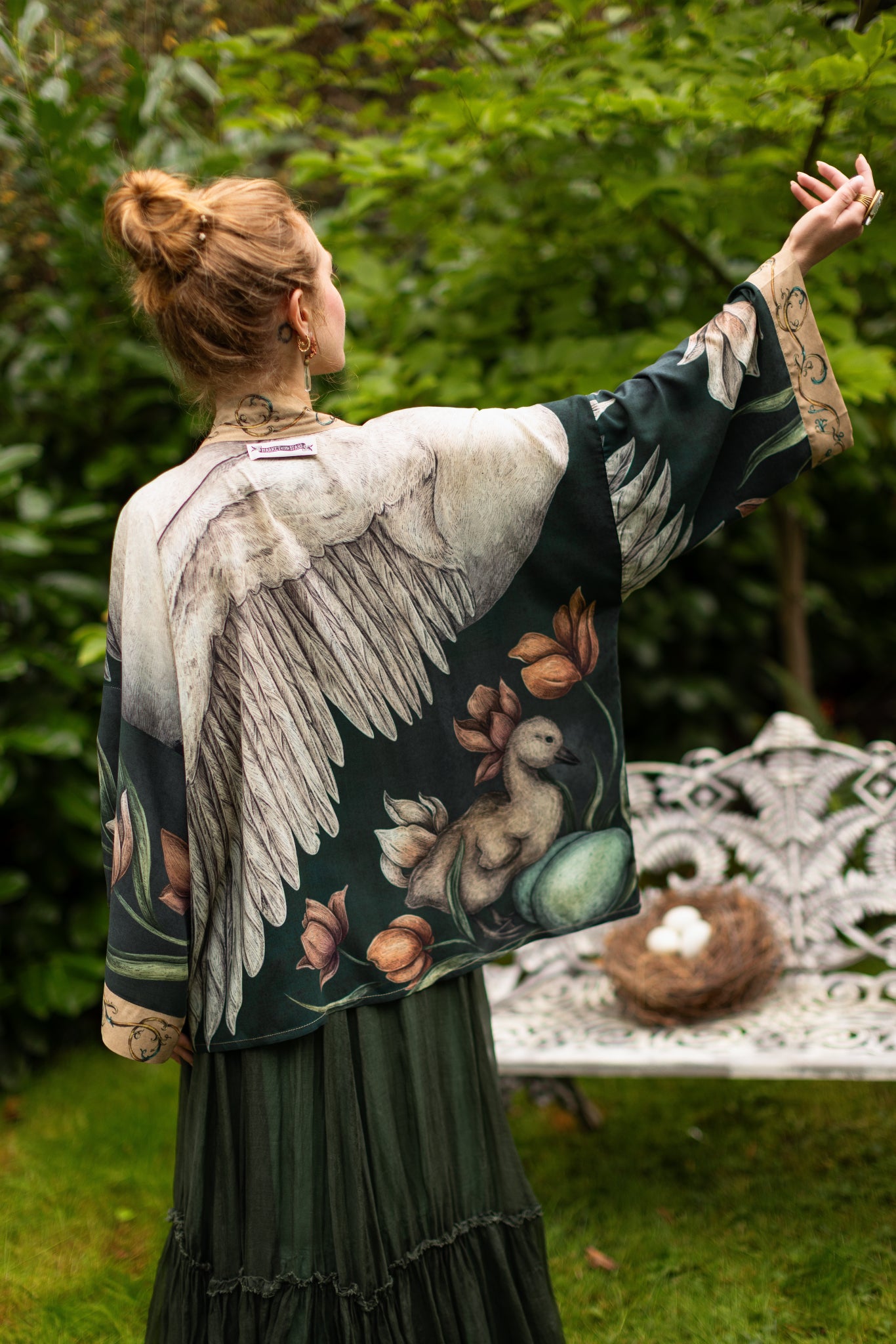 Model wearing a cropped-length duster created in collaboration with artist Jessica Roux and features a trompe l'oeil swan symbolizing protection, love, and grace - Market of Stars.