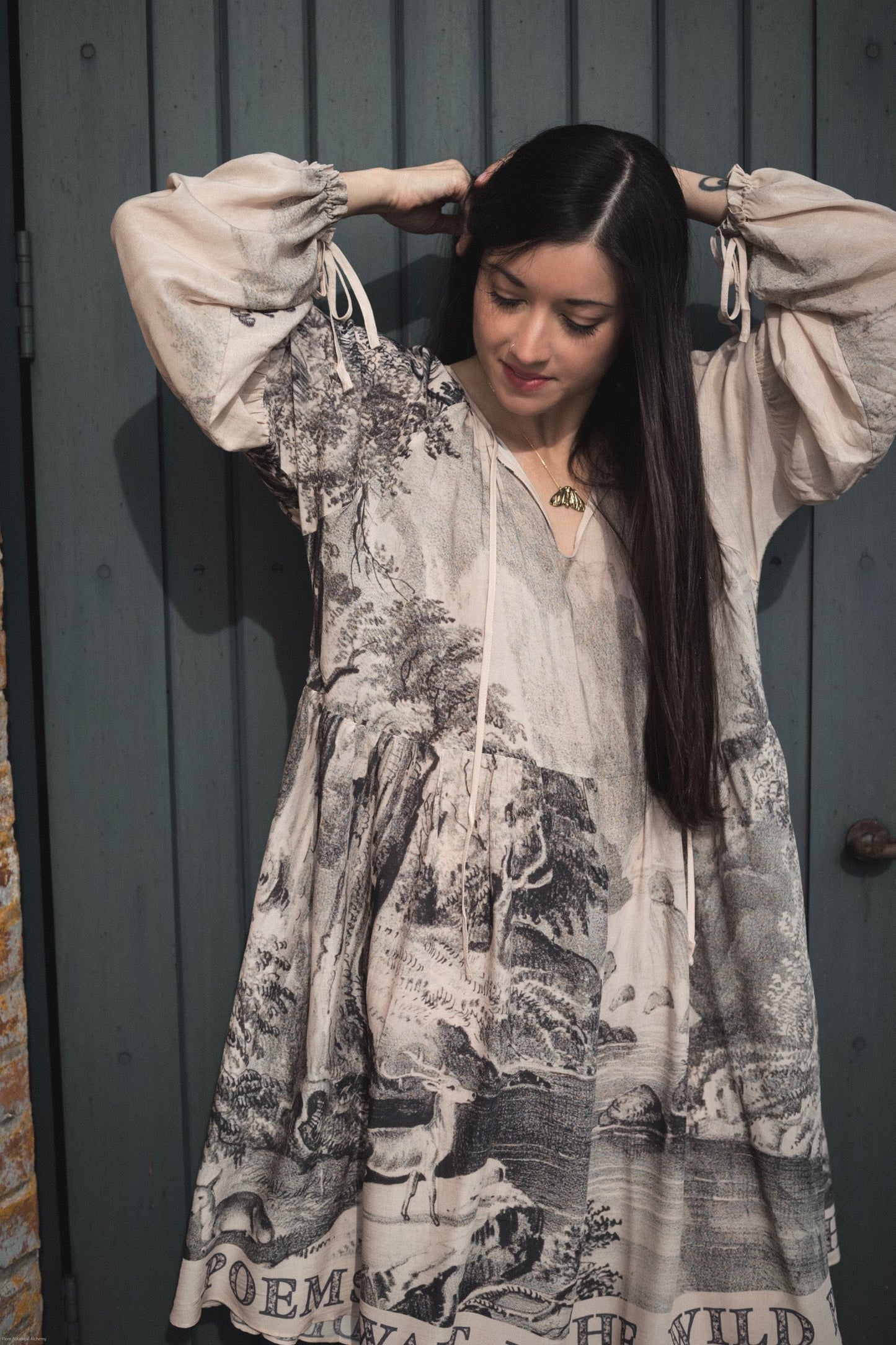 Model wearing knee-length dress with long sleeves featuring vintage print of a forest, songbirds and sunshine - Market of Stars