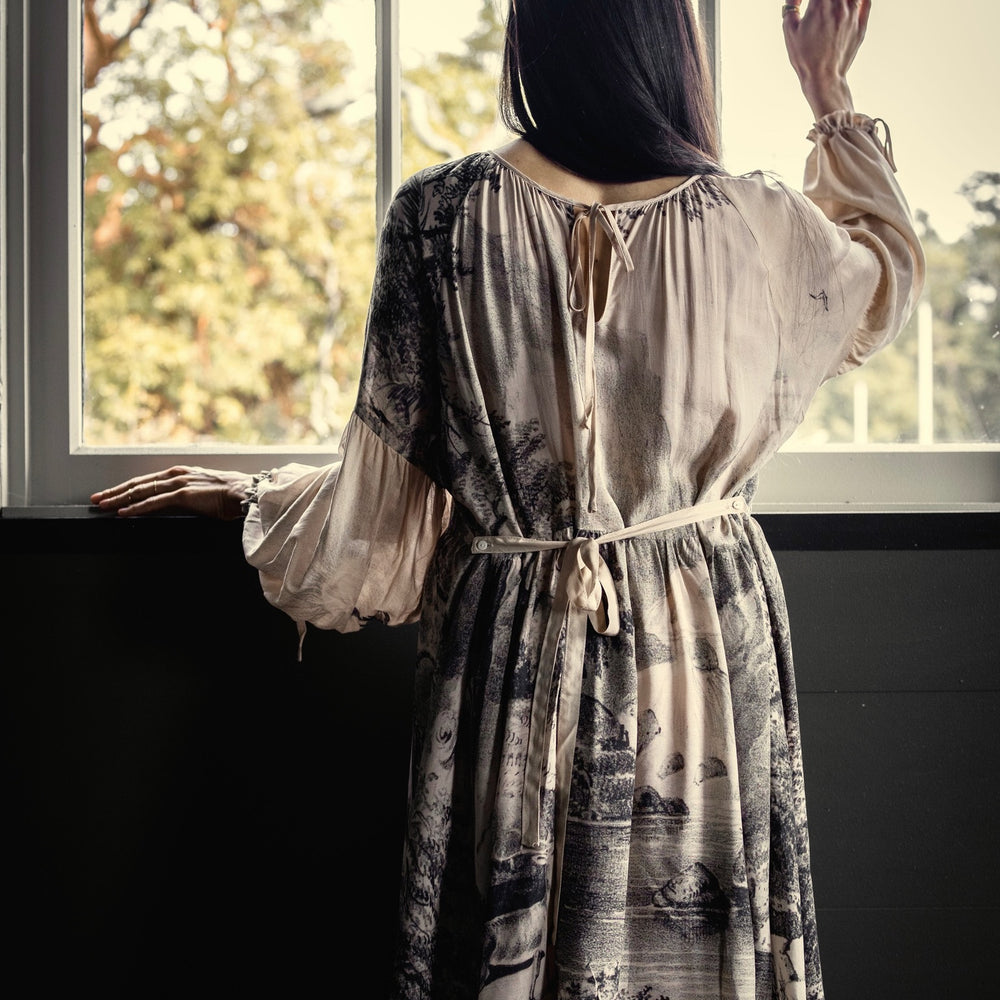 
                  
                    Model wearing knee-length dress with long sleeves featuring vintage print of a forest, songbirds and sunshine - Market of Stars
                  
                