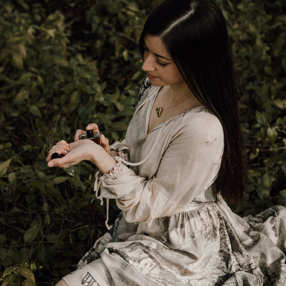 
                  
                    Model wearing knee-length dress with long sleeves featuring vintage print of a forest, songbirds and sunshine - Market of Stars
                  
                