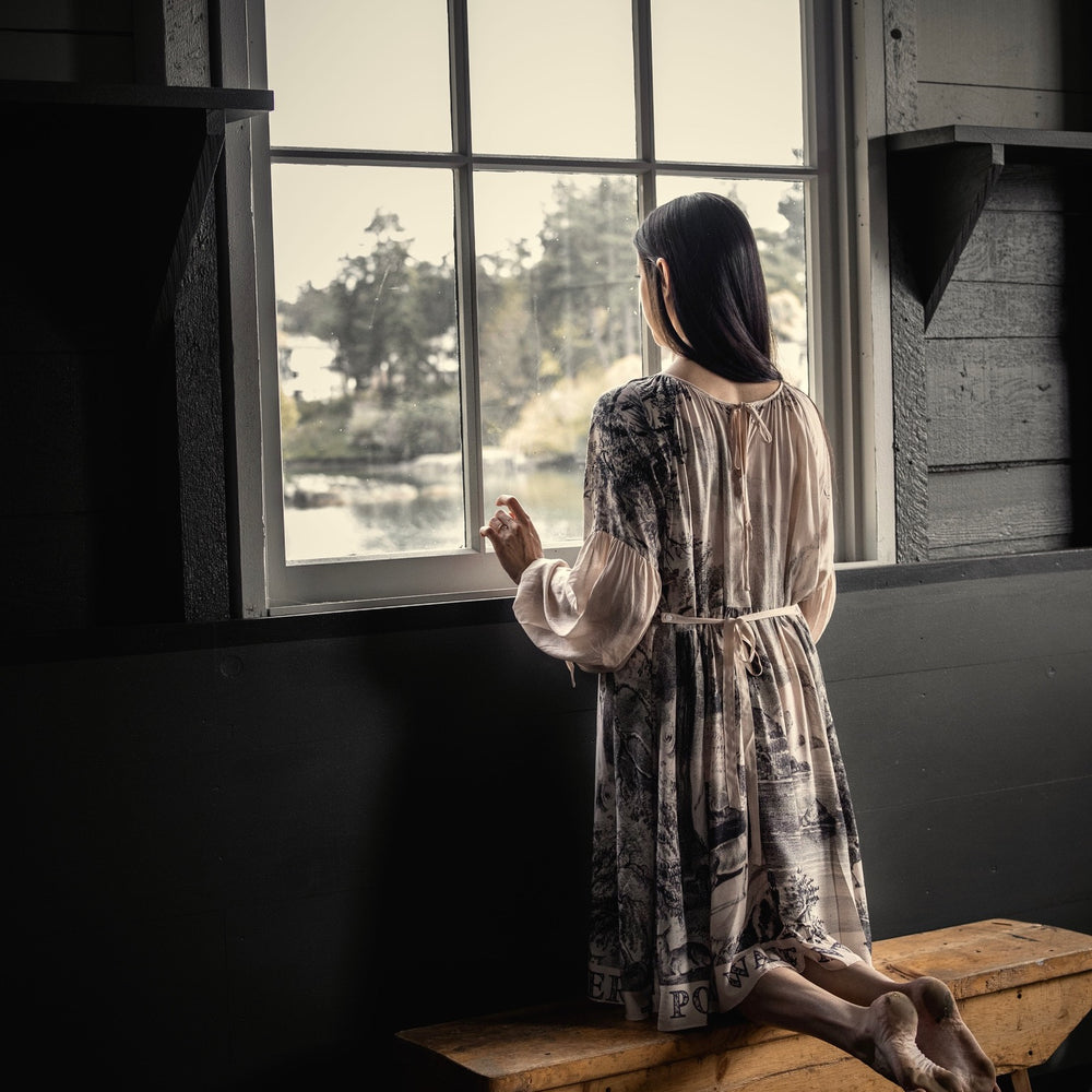 
                  
                    Model wearing knee-length dress with long sleeves featuring vintage print of a forest, songbirds and sunshine - Market of Stars
                  
                