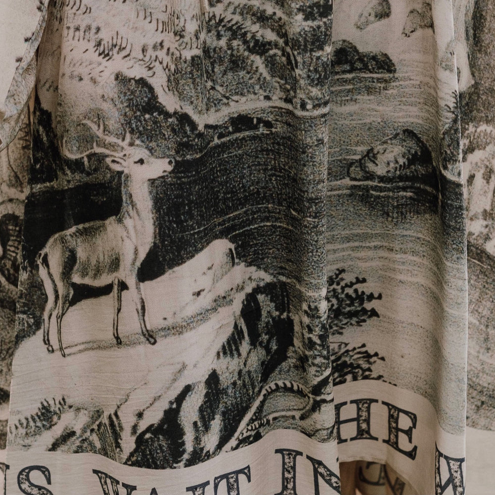 
                  
                    Model wearing knee-length dress with long sleeves featuring vintage print of a forest, songbirds and sunshine - Market of Stars
                  
                