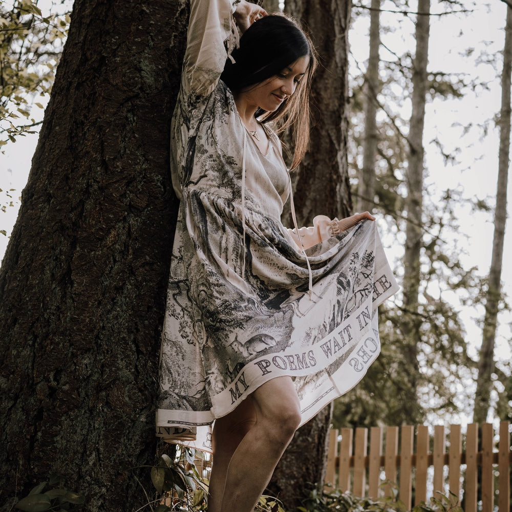 
                  
                    Model wearing knee-length dress with long sleeves featuring vintage print of a forest, songbirds and sunshine - Market of Stars
                  
                