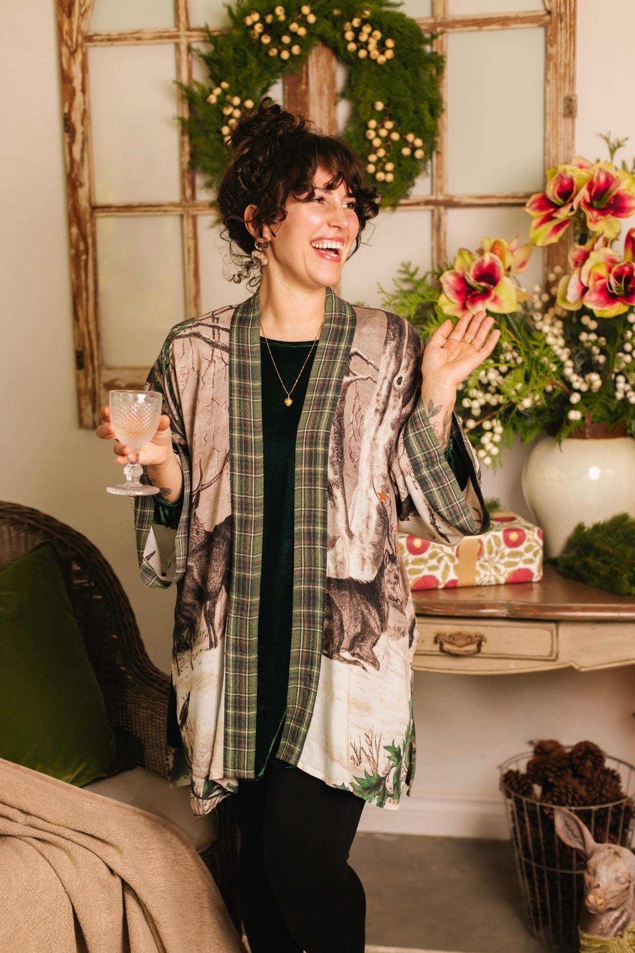 Model wearing a bamboo viscose mid-length duster with Victorian-era images from holiday greeting cards — including reindeer in the snow, a little fir tree, golden stars, and traditional plaid trim - Market of Stars