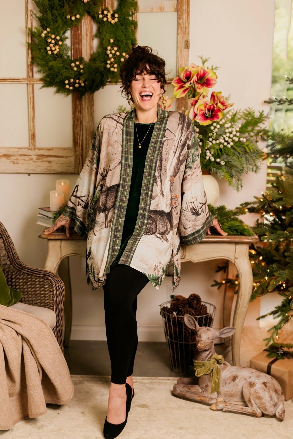 Model wearing a bamboo viscose mid-length duster with Victorian-era images from holiday greeting cards — including reindeer in the snow, a little fir tree, golden stars, and traditional plaid trim - Market of Stars