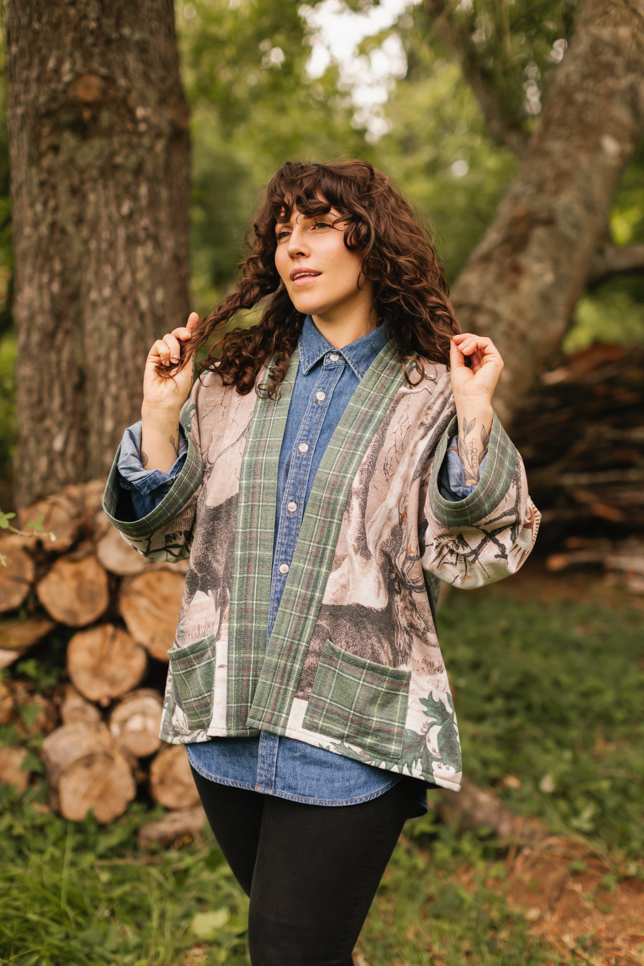 Model wearing a fleece lined jacket with pockets with Victorian-era images from holiday greeting cards — including reindeer in the snow, a little fir tree, golden stars, and traditional plaid trim - Market of Stars