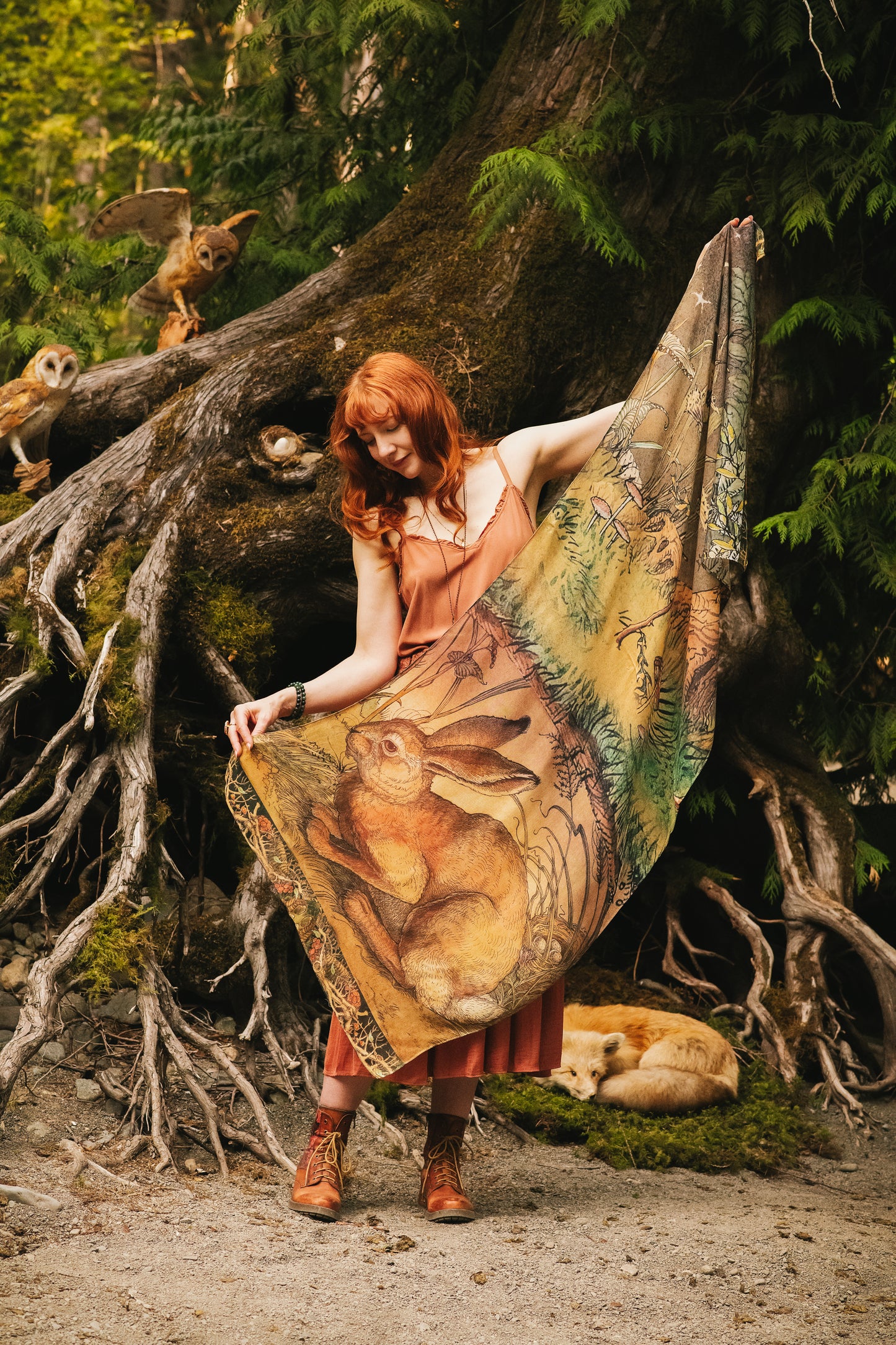 Model wearing a bamboo-viscose scarf where a noble rabbit rests deep within an underground burrow, surrounded by the warmth and safety of the earth. Created in collaboration with Charles van Sandwyck - Market of Stars