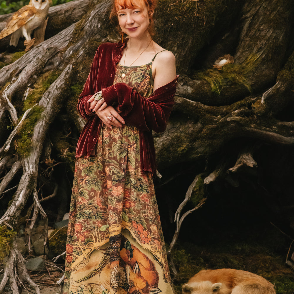 
                  
                    Model wearing a bamboo-viscose maxi length slip dress where even the unlikeliest of friends...a fox and a pheasant...find warmth in each other’s company. Created in collaboration with Charles van Sandwyck - Market of Stars
                  
                