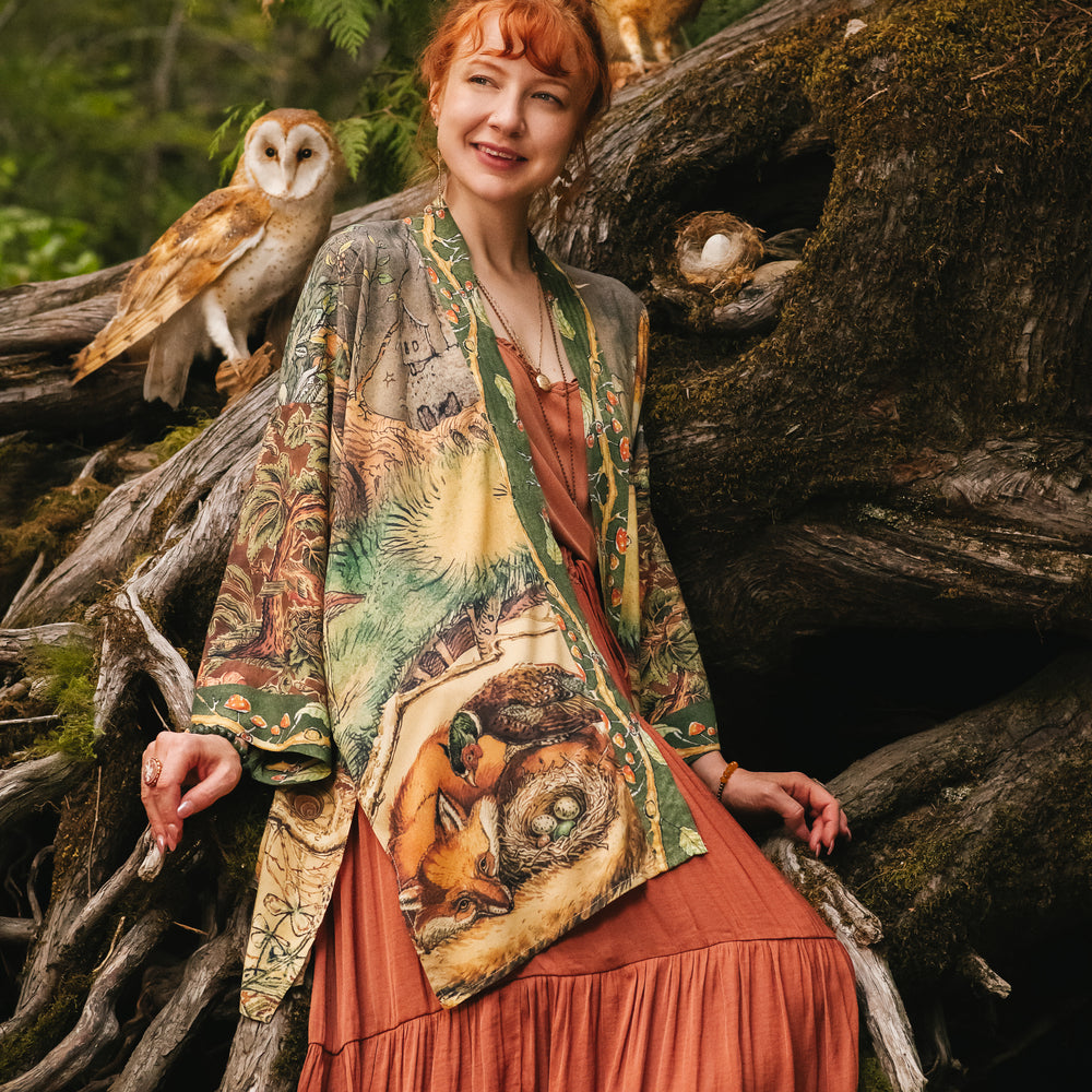 Model wearing a bamboo-viscose mid-length duster kimono robe where even the unlikeliest of friends...a fox and a pheasant...find warmth in each other’s company. Created in collaboration with Charles van Sandwyck - Market of Stars
