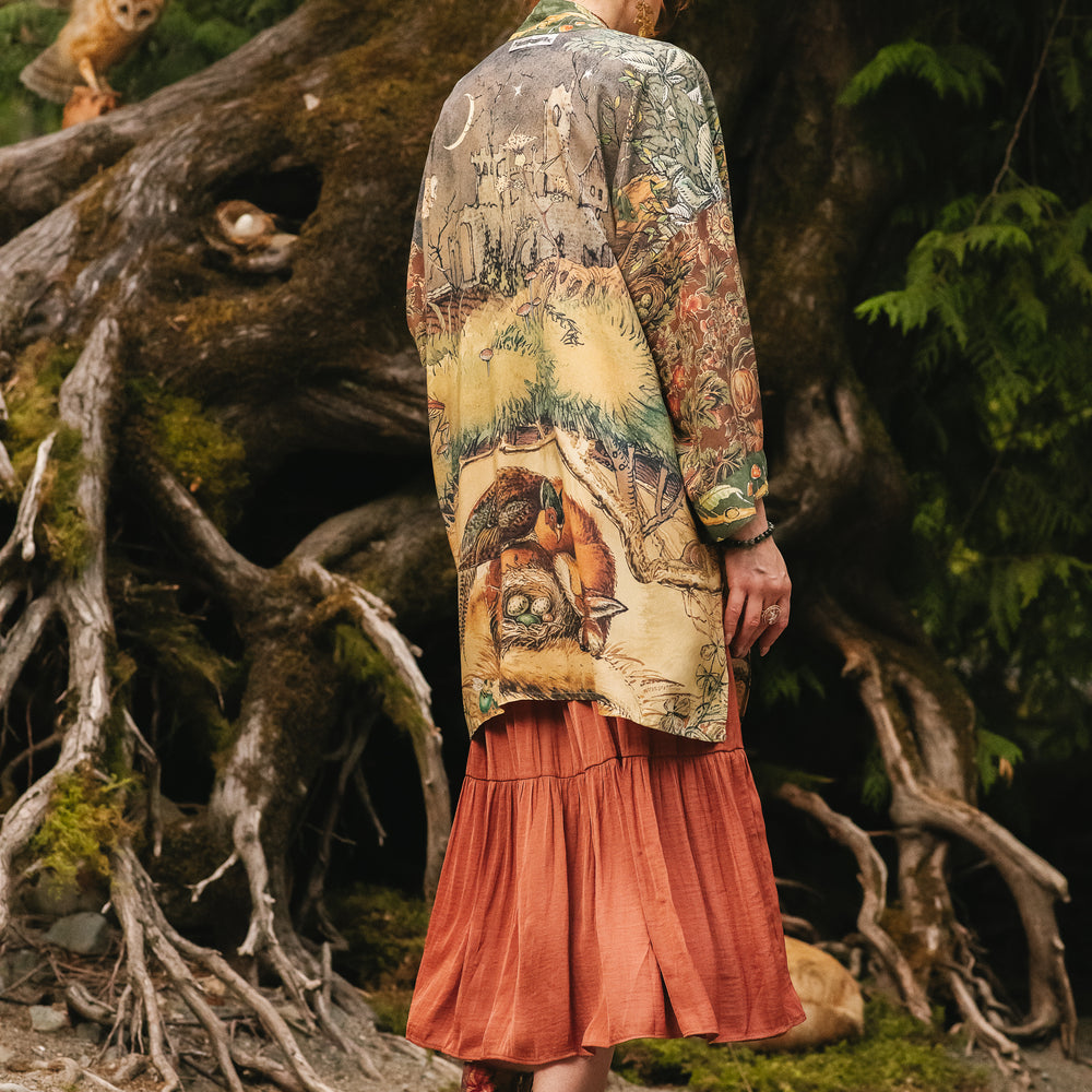 
                  
                    Model wearing a bamboo-viscose mid-length duster kimono robe where even the unlikeliest of friends...a fox and a pheasant...find warmth in each other’s company. Created in collaboration with Charles van Sandwyck - Market of Stars
                  
                