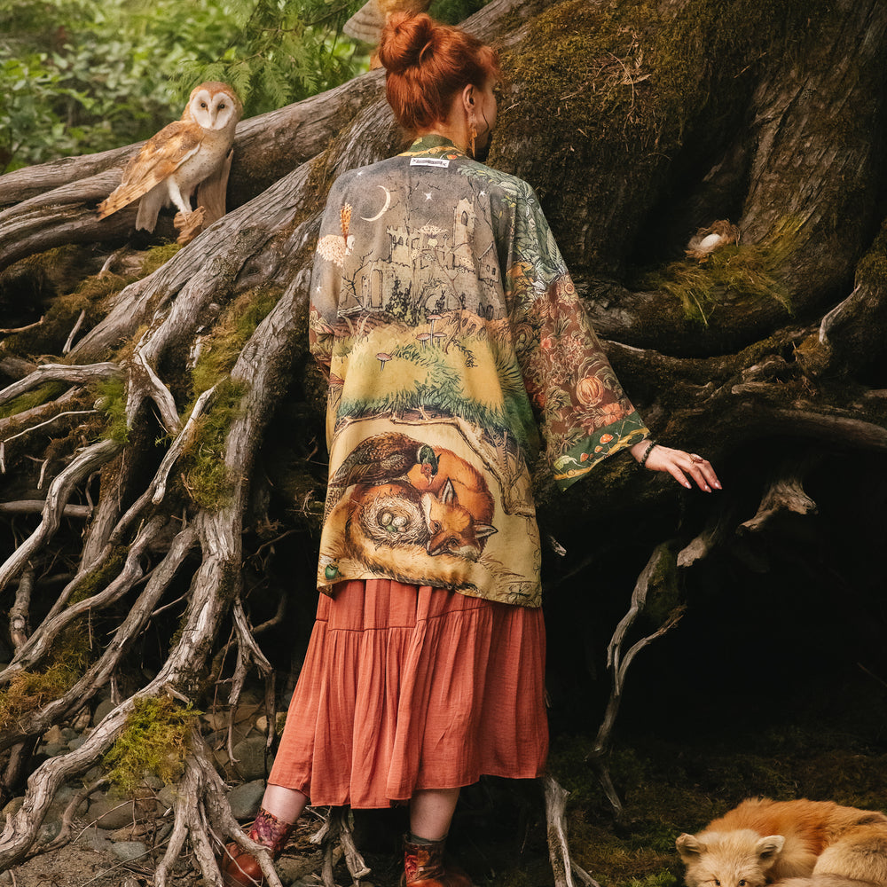 
                  
                    Model wearing a bamboo-viscose mid-length duster kimono robe where even the unlikeliest of friends...a fox and a pheasant...find warmth in each other’s company. Created in collaboration with Charles van Sandwyck - Market of Stars
                  
                
