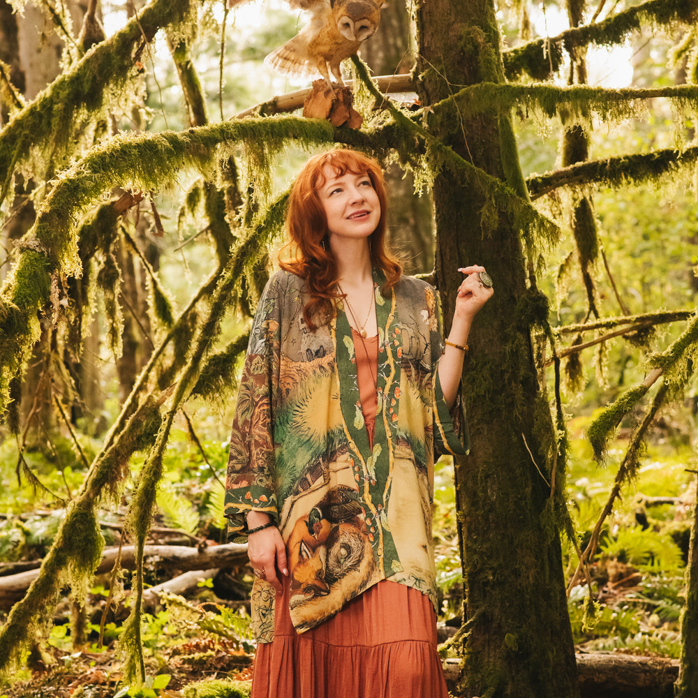 
                  
                    Model wearing a bamboo-viscose mid-length duster kimono robe where even the unlikeliest of friends...a fox and a pheasant...find warmth in each other’s company. Created in collaboration with Charles van Sandwyck - Market of Stars
                  
                